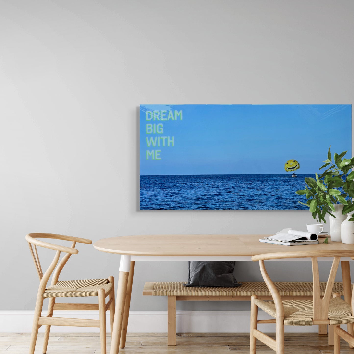 'Dream Big With Me' original landscape mixed media artwork by Christen Oatley, featuring a yellow parasail above the Mediterranean Sea, displayed above a minimalist dining table. Created on a 24x48 inch Canadian birchwood panel with acrylic screen print and resin finish.
