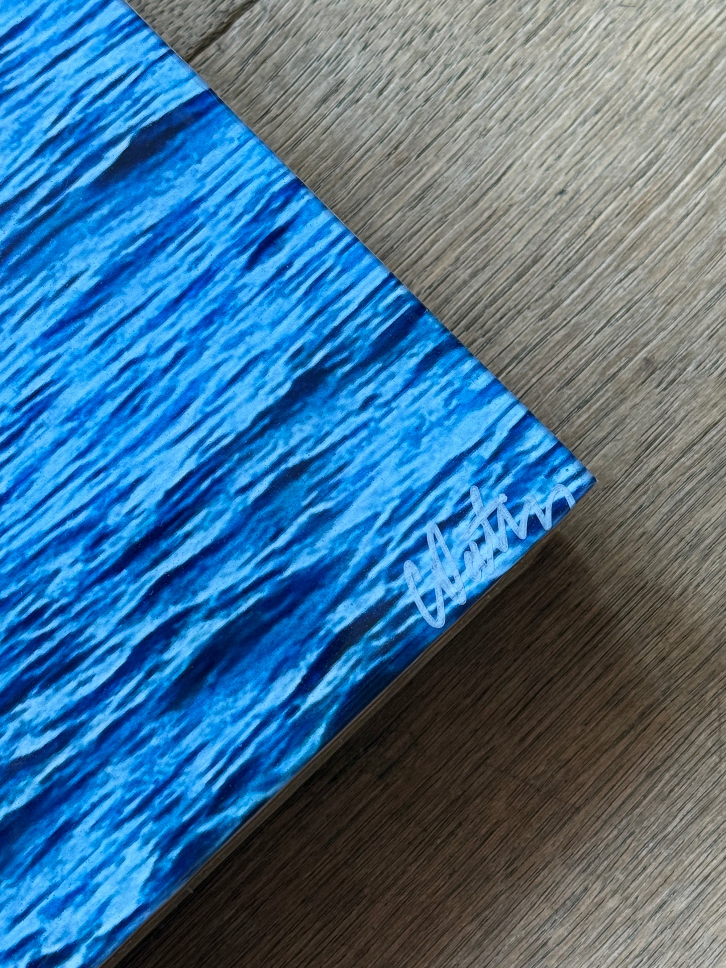 Close up: Dream Big With Me' original landscape mixed media artwork by Christen Oatley, featuring a bright yellow smiley face parasail floating over the deep blue Mediterranean Sea beneath lime green acrylic text on a 24x48 inch Canadian birchwood panel.