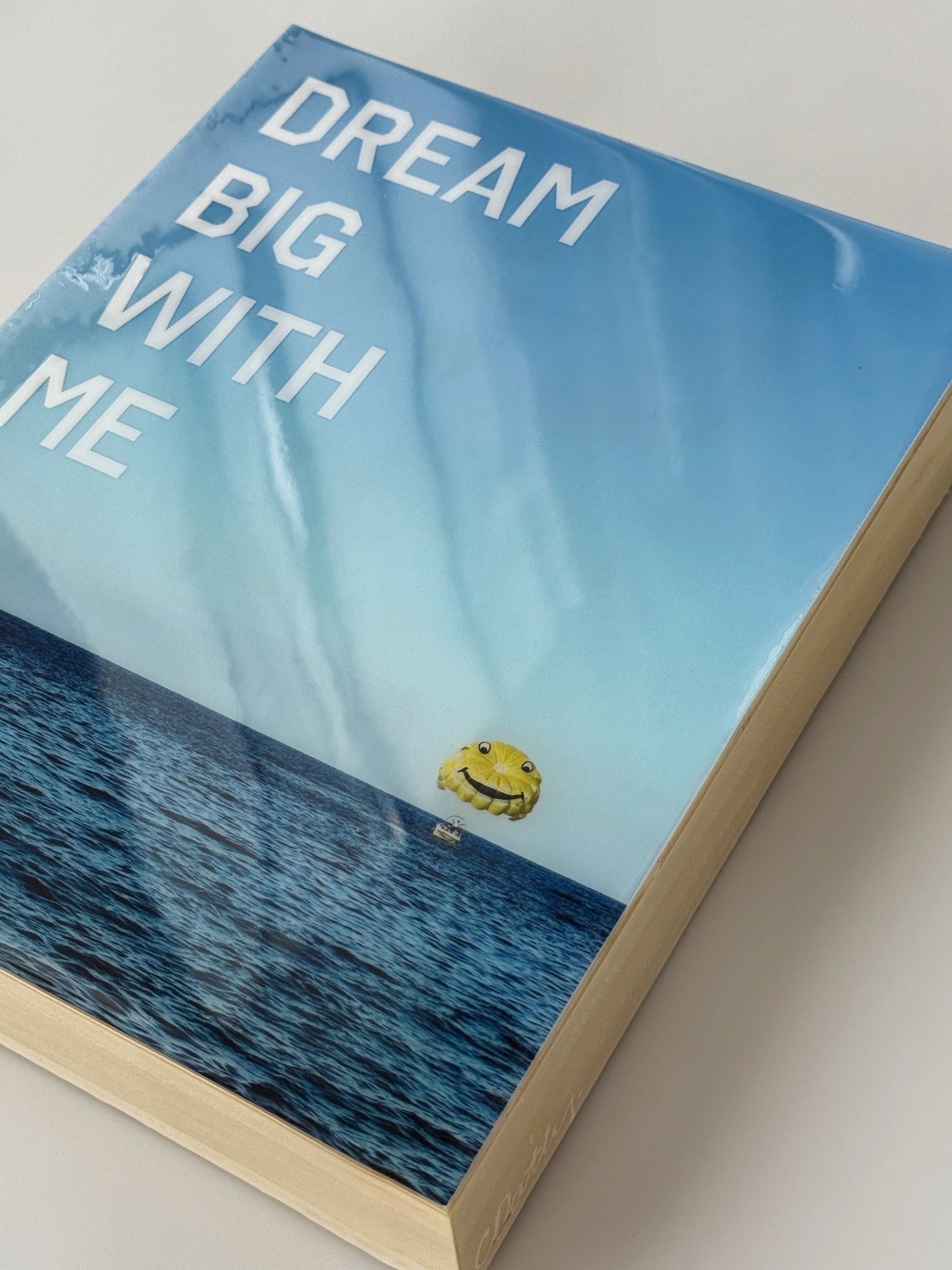 Side Profile: 'Dream Big With Me' limited edition mixed media artwork by Christen Oatley, featuring a yellow parasail over the Mediterranean Sea with bold white acrylic text, created on an 8x10 inch Canadian birchwood panel with resin finish.