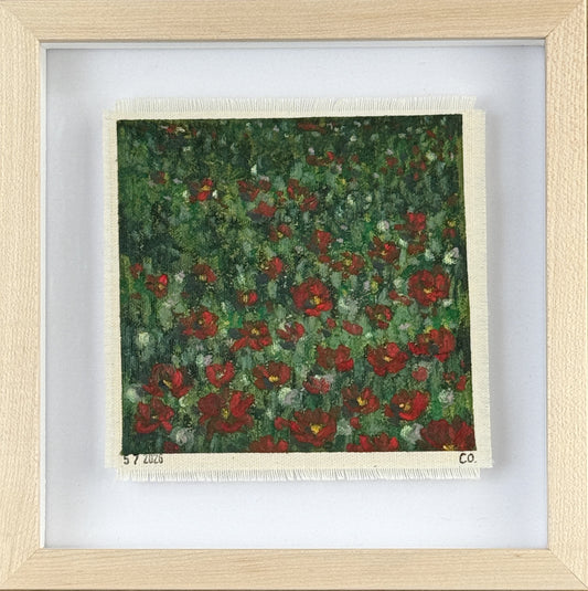Framed textile with red floral poppy pattern on a green background